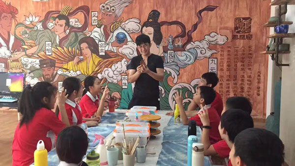 Qu Junmeng shows a class of students how to make miniature ceramic figures.(Photo provided to chinadaily.com.cn) Qu Junmeng shows a class of students how to make miniature ceramic figures.(Photo provided to chinadaily.com.cn)