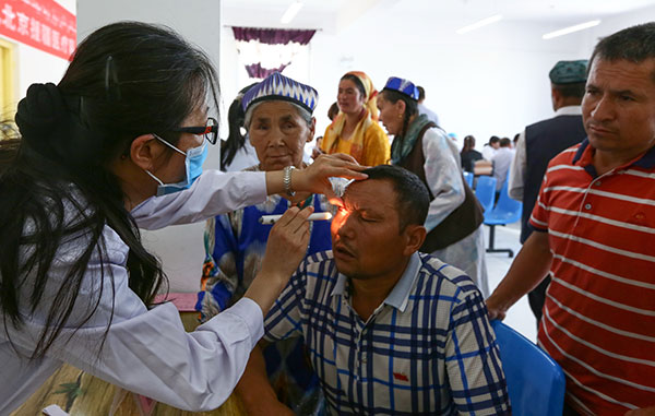 Liu Weihua, an eye doctor from Beijing Tongren Hospital, checks a resident of Hotan, in the Xinjiang Uygur autonomous region, earlier this month.(Xu Zhuzhu/For China Daily) Liu Weihua, an eye doctor from Beijing Tongren Hospital, checks a resident of Hotan, in the Xinjiang Uygur autonomous region, earlier this month.(Xu Zhuzhu/For China Daily)