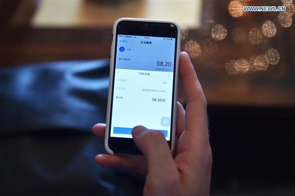 Tim Clancy, an Australian who has lived in Hangzhou for six years with his Chinese wife, pays the water bill through mobile phone in Hangzhou, capital of east China's Zhejiang Province, April 14, 2017. (Xinhua Photo)