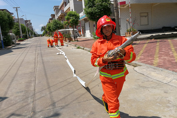 Wu Shuchun carries a firefighting hose at Shantou village, Dadeng Island in East China's Fujian province, on July 24, 2017. (Photo provided to chinadaily.com.cn) Wu Shuchun carries a firefighting hose at Shantou village, Dadeng Island in East China's Fujian province, on July 24, 2017. (Photo provided to chinadaily.com.cn)