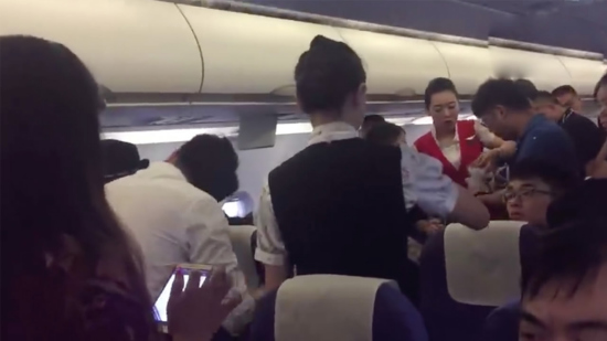 Passengers give an aid to a female passenger who passes out due to stuffiness in the cabin. /Screenshot Passengers give an aid to a female passenger who passes out due to stuffiness in the cabin. /Screenshot