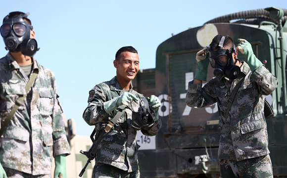 Chinese soldiers (from left) Liu Wei, Sodnam Tobgyal and Xue Fanyu prepare for an event that simulates a chemical warfare situation. (Photo: Zou Hong/For China Daily) Chinese soldiers (from left) Liu Wei, Sodnam Tobgyal and Xue Fanyu prepare for an event that simulates a chemical warfare situation. (Photo: Zou Hong/For China Daily)