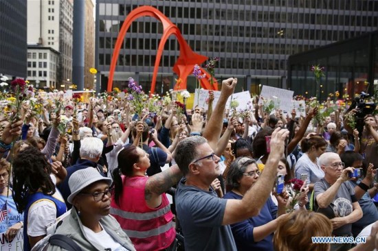 People raise flowers during an evening vigil at Federal Plaza in Chicago, the United States, on Aug. 13, 2017. Several hundred people joined a Sunday evening vigil at Federal Plaza in downtown Chicago, for those who fell victim to the violence in Charlottesville of Virginia during the weekend.(Xinhua/Wang Ping) People raise flowers during an evening vigil at Federal Plaza in Chicago, the United States, on Aug. 13, 2017. Several hundred people joined a Sunday evening vigil at Federal Plaza in downtown Chicago, for those who fell victim to the violence in Charlottesville of Virginia during the weekend.(Xinhua/Wang Ping)