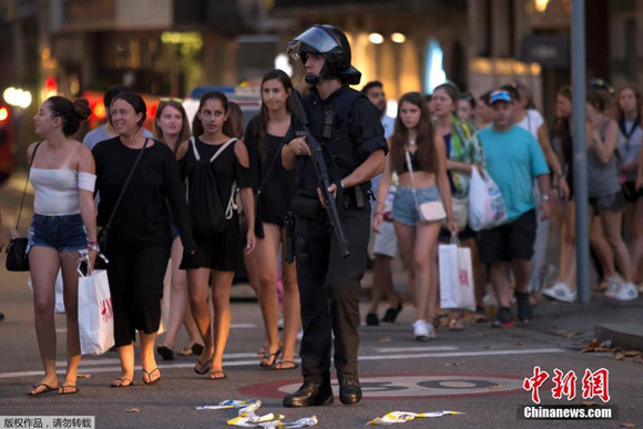 An armed policeman patrols on the street after a white van speeds from the Placa Catalunya down the Las Ramblas thoroughfare in Barcelona's busy tourist area, killing dozens of people. (Photo/Agencies) An armed policeman patrols on the street after a white van speeds from the Placa Catalunya down the Las Ramblas thoroughfare in Barcelona's busy tourist area, killing dozens of people. (Photo/Agencies)