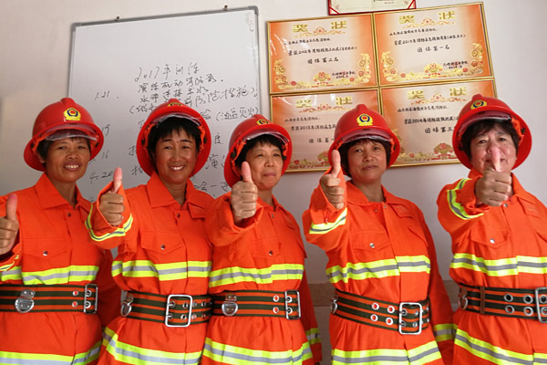 Wu Shuchun, 2nd from right, poses with other brigade members in front of the awards they've won in Shantou village, Dadeng Island in East China's Fujian province, on July 24, 2017. (Photo provided to chinadaily.com.cn) Wu Shuchun, 2nd from right, poses with other brigade members in front of the awards they've won in Shantou village, Dadeng Island in East China's Fujian province, on July 24, 2017. (Photo provided to chinadaily.com.cn)