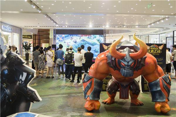 People gather at a department store to watch and play in a King of Glory challenge held by the store in Shanghai. (Photo by Li Sanxian, Yin Ming and Wang Gang/For China Daily) People gather at a department store to watch and play in a King of Glory challenge held by the store in Shanghai. (Photo by Li Sanxian, Yin Ming and Wang Gang/For China Daily)