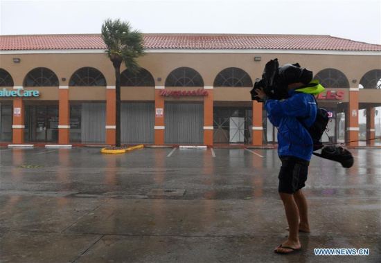 A cameraman takes video among rain and strong winds as hurricane Irma arrives, in Miami, Florida, the United States, on Sept. 10, 2017. Category Four Hurricane Irma on Sunday morning made landfall in the Florida Keys with gust wind speed of 171 km/h, according to the National Hurricane Center (NHC). (Xinhua/Yin Bogu) A cameraman takes video among rain and strong winds as hurricane Irma arrives, in Miami, Florida, the United States, on Sept. 10, 2017. Category Four Hurricane Irma on Sunday morning made landfall in the Florida Keys with gust wind speed of 171 km/h, according to the National Hurricane Center (NHC). (Xinhua/Yin Bogu)