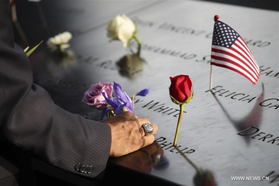 A man places a flower on a plate on which the names of 9/11 victims were inscribed around the South Pool at the National September 11 Memorial and Museum in New York, the United States, on Sept. 11, 2017. (Xinhua/Wang Ying) A man places a flower on a plate on which the names of 9/11 victims were inscribed around the South Pool at the National September 11 Memorial and Museum in New York, the United States, on Sept. 11, 2017. (Xinhua/Wang Ying)