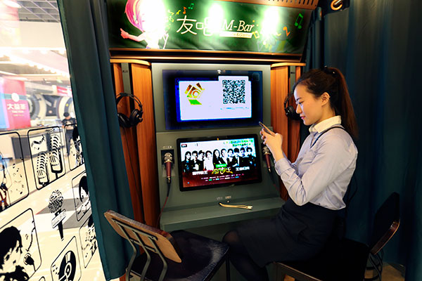 A woman connects her mobile phone with a mini-karaoke system in a shopping mall in Beijing. (FENG YONGBIN/CHINA DAILY) A woman connects her mobile phone with a mini-karaoke system in a shopping mall in Beijing. (FENG YONGBIN/CHINA DAILY)