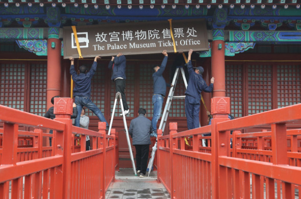 Workers take down a sign at the Palace Museum's ticket office in Beijing on Tuesday. (Photo by Jiang Dong/China Daily) Workers take down a sign at the Palace Museum's ticket office in Beijing on Tuesday. (Photo by Jiang Dong/China Daily)
