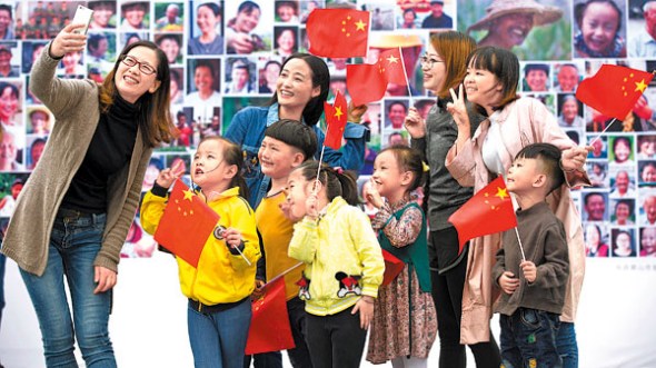 Pupils and teachers pose for a selfie in front of a smiling face wall exhibit in Anhui province on Wednesday. The exhibit, in the former New Fourth Army Memorial Hall, celebrates the 19th Party Congress, starting next Wednesday. (CAO XIAODONG / FOR CHINA DAILY) Pupils and teachers pose for a selfie in front of a smiling face wall exhibit in Anhui province on Wednesday. The exhibit, in the former New Fourth Army Memorial Hall, celebrates the 19th Party Congress, starting next Wednesday. (CAO XIAODONG / FOR CHINA DAILY)