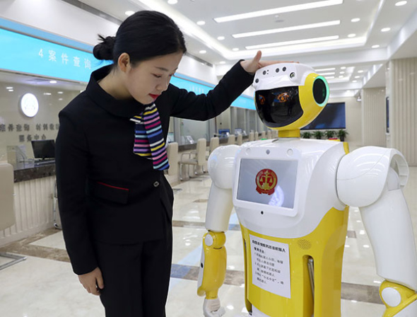 A staff member interacts with Xiaofa, a robot that provides simple legal advice and guidance for litigants, at Beijing No 1 Intermediate People's Court on Thursday. (Zou Hong/China Daily) A staff member interacts with Xiaofa, a robot that provides simple legal advice and guidance for litigants, at Beijing No 1 Intermediate People's Court on Thursday. (Zou Hong/China Daily)