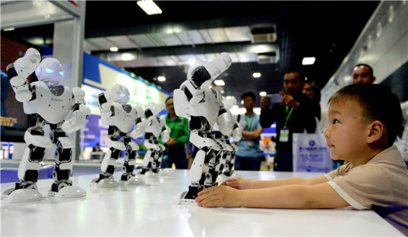 A boy plays with dancing robots at an intelligent devices exhibition in Luoyang, Henan province, in May. (Photo/Xinhua) A boy plays with dancing robots at an intelligent devices exhibition in Luoyang, Henan province, in May. (Photo/Xinhua)
