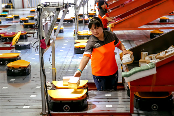 An employee of Shentong Express, a delivery company, uses robots to scan, weigh and sort mail automatically. More than 700 robots work at the company's sorting center in Yiwu, Zhejiang province. (Photo/Xinhua) An employee of Shentong Express, a delivery company, uses robots to scan, weigh and sort mail automatically. More than 700 robots work at the company's sorting center in Yiwu, Zhejiang province. (Photo/Xinhua)