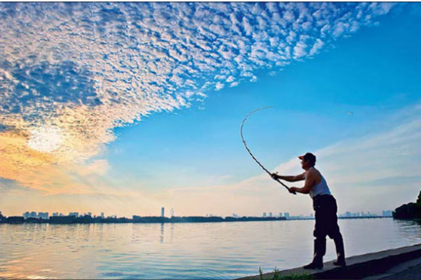 A fisherman casts off at Lihu Lake, Wuxi, in the early morning. (Photo by Rong Yiqing / For China Daily) A fisherman casts off at Lihu Lake, Wuxi, in the early morning. (Photo by Rong Yiqing / For China Daily)