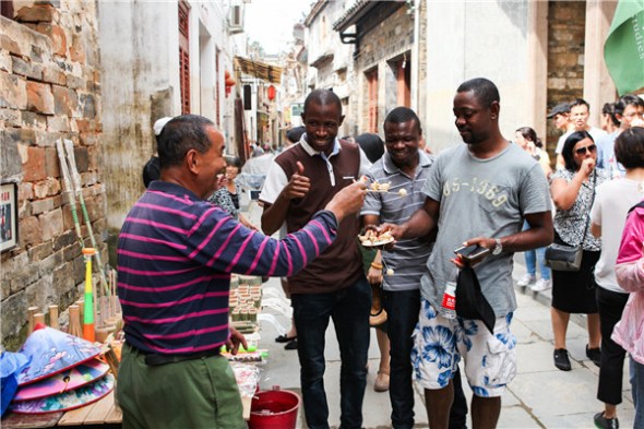 Nigerian Tochukwu Innocent Okeke (right) shopping for souvenirs in Wuyuan, Jiangxi province. (Photo by Lan Jian/For China Daily) Nigerian Tochukwu Innocent Okeke (right) shopping for souvenirs in Wuyuan, Jiangxi province. (Photo by Lan Jian/For China Daily)