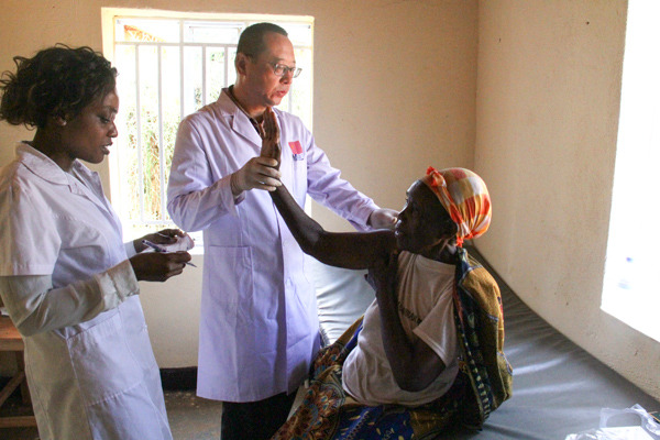 A member of the 18th China Medical Team in Rwanda examines a patient on Wednesday. (Photo/Xinhua)