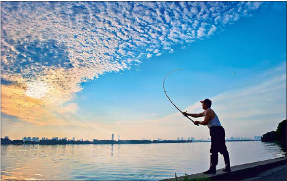 A fisherman casts off at Lihu Lake, Wuxi, in the early morning. (Rong Yiqing / For China Daily) A fisherman casts off at Lihu Lake, Wuxi, in the early morning. (Rong Yiqing / For China Daily)