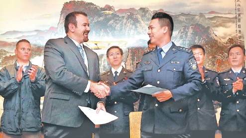 A representative of the International Cooperation Department of the Ministry of Public Security (right) hands the memorandum of understanding to a representative of the United States Department of Justice in Shanghai on Oct. 16, 2017. (FAN JUN/XINHUA) A representative of the International Cooperation Department of the Ministry of Public Security (right) hands the memorandum of understanding to a representative of the United States Department of Justice in Shanghai on Oct. 16, 2017. (FAN JUN/XINHUA)