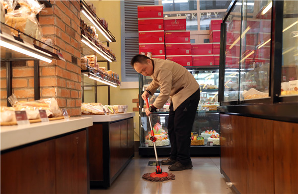 Liu Shunli, 24, who has Down syndrome, mops the floor at a branch of the Auspicious Phoenix Bakery in Beijing.(Photo by Zou Hong/China Daily) Liu Shunli, 24, who has Down syndrome, mops the floor at a branch of the Auspicious Phoenix Bakery in Beijing.(Photo by Zou Hong/China Daily)