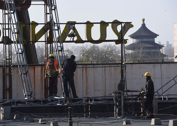 Construction workers remove a billboard from the roof of a building near Tiantan Park in Beijing on Nov 28. (Photo/Xinhua) Construction workers remove a billboard from the roof of a building near Tiantan Park in Beijing on Nov 28. (Photo/Xinhua)