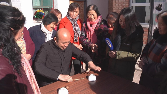Village's CPC Secretary Wang Zhuhong plays a walnuts trick. /CGTN Photo Village's CPC Secretary Wang Zhuhong plays a walnuts trick. /CGTN Photo