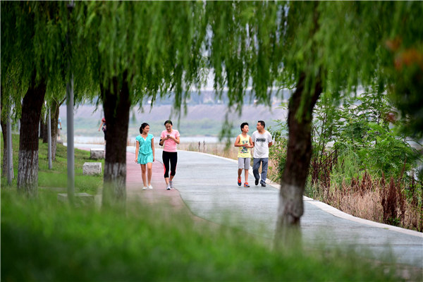 People stroll on a walking path near an embankment of Hanjiang River in Ankang, Shaanxi province. (Shao Rui/Xinhua) People stroll on a walking path near an embankment of Hanjiang River in Ankang, Shaanxi province. (Shao Rui/Xinhua)