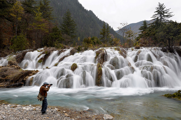 A photographer takes a picture of Shuanglonghai Waterfall, a new scenic spot formed after the earthquake in Jiuzhaigou, Sichuan province, in November. (Hua Xiaofeng/for China Daily) A photographer takes a picture of Shuanglonghai Waterfall, a new scenic spot formed after the earthquake in Jiuzhaigou, Sichuan province, in November. (Hua Xiaofeng/for China Daily)