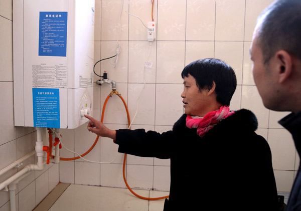 Qi Si'nyu, a villager in Hebei, shows off her new gas-fired boiler. (Photo by WANG JING/CHINA DAILY) Qi Si'nyu, a villager in Hebei, shows off her new gas-fired boiler. (Photo by WANG JING/CHINA DAILY)