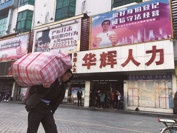 Migrant workers gather in front of one of the many labor recruitment agencies in Sanhe marketplace in Longhua, Shenzhen, Guangdong province. (Photo: China Daily/Roy Liu) Migrant workers gather in front of one of the many labor recruitment agencies in Sanhe marketplace in Longhua, Shenzhen, Guangdong province. (Photo: China Daily/Roy Liu)