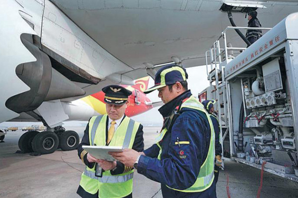 Sun Jianfeng (left), president of Hainan Airlines who is also a crew member of China's first bio-fuel international flight, checks the airplane's condition report at the Beijing Capital International Airport before departure for Chicago on Nov 21. (Photo provided to China Daily) Sun Jianfeng (left), president of Hainan Airlines who is also a crew member of China's first bio-fuel international flight, checks the airplane's condition report at the Beijing Capital International Airport before departure for Chicago on Nov 21. (Photo provided to China Daily)