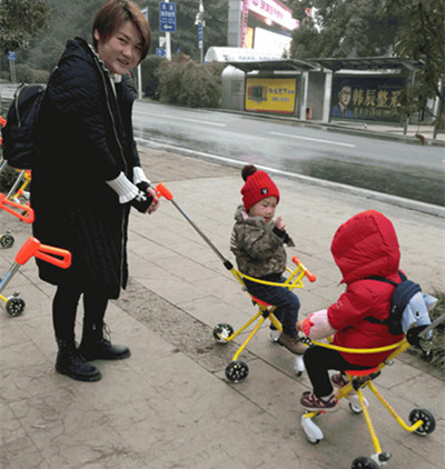 Two children ride yellow shared strollers as a woman watches them in Liyuan Square in Wuhan, Hubei province, on Sunday. Provided to CHINA DAILY Two children ride yellow shared strollers as a woman watches them in Liyuan Square in Wuhan, Hubei province, on Sunday. Provided to CHINA DAILY
