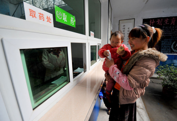 A woman collects medication prescribed after a free checkup as part of a A woman collects medication prescribed after a free checkup as part of a
