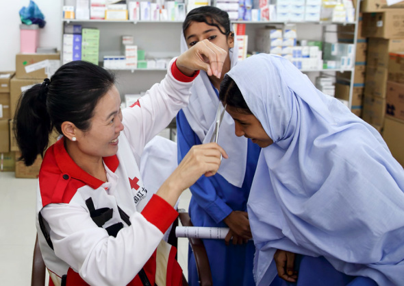 Fu Wenhuan, a doctor with the Chinese Red Cross foreign aid medical team takes a hair sample as part of checkups given to students from the China-Pakistan Government Primary School Faqeer Colony in Gwadar, Pakistan, on Wednesday.(Photo by WANG JING/CHINA DAILY)
