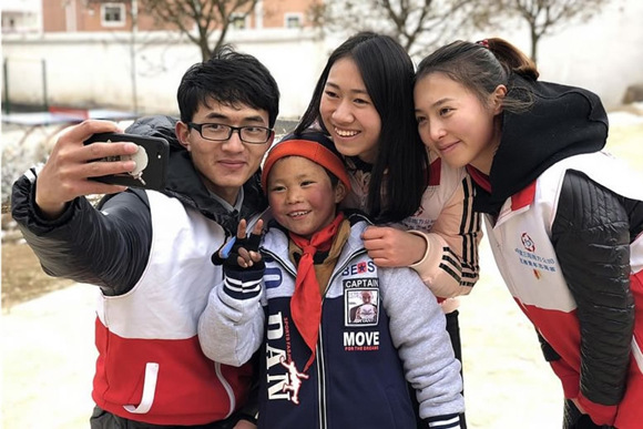Volunteers pose with 8-year-old Wang Fuman after helping him put on a pair of gloves. (Photo/Chinadaily) Volunteers pose with 8-year-old Wang Fuman after helping him put on a pair of gloves. (Photo/Chinadaily)