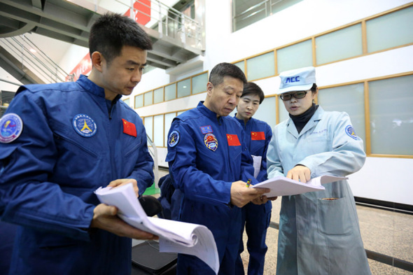 Chen Dong, Liu Wang and Liu Yang talk with a team member during flight training at the center. (Feng Yongbin/China Daily) Chen Dong, Liu Wang and Liu Yang talk with a team member during flight training at the center. (Feng Yongbin/China Daily)
