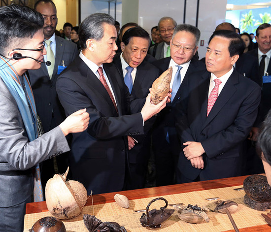 Foreign Minister Wang Yi (second from the left) learns about coconut sculpture from Liu Cigui (right), secretary of Hainan Provincial Committee of the Communist Party of China, in Beijing on Friday. Wang Zhuangfei / China Daily Foreign Minister Wang Yi (second from the left) learns about coconut sculpture from Liu Cigui (right), secretary of Hainan Provincial Committee of the Communist Party of China, in Beijing on Friday. Wang Zhuangfei / China Daily
