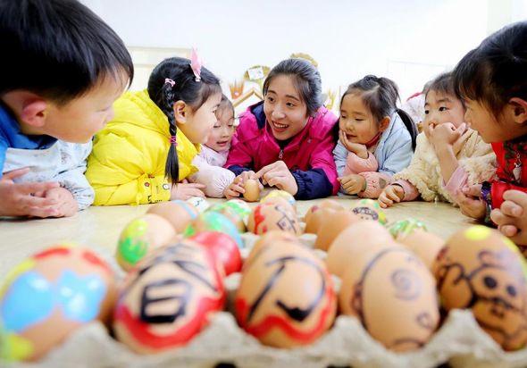 Kids at a kindergarten in Jiangsu province play a game of standing spring eggs with their teacher on Spring Equinox, March 20, 2017. (Photo/Xinhua) Kids at a kindergarten in Jiangsu province play a game of standing spring eggs with their teacher on Spring Equinox, March 20, 2017. (Photo/Xinhua)