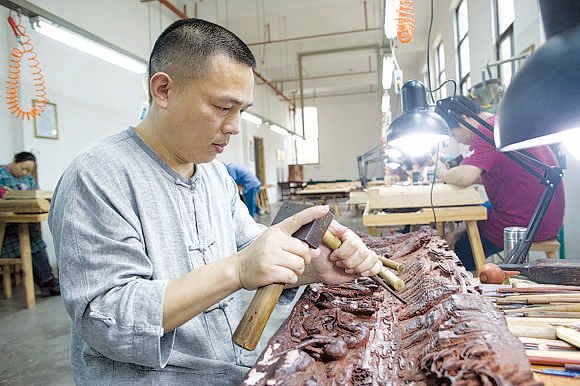 Hu Xianmin is an inheritor of the craft of Dongyang wood carving, which was in 2006 listed as a national intangible cultural heritage. (PHOTOS BY GAO ERQIANG\CHINA DAILY) Hu Xianmin is an inheritor of the craft of Dongyang wood carving, which was in 2006 listed as a national intangible cultural heritage. (PHOTOS BY GAO ERQIANG\CHINA DAILY)