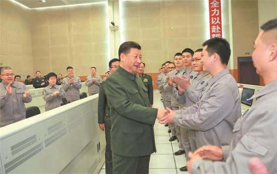 President Xi Jinping, who also leads the Party and military, talks with scientists and technicians about their research, work and lives as he visits a satellite launch center in Sichuan province on Saturday. Li Gang/Xinhua