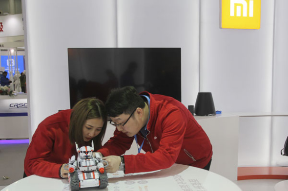 Two technicians fine-tune a robot at the stall of Xiaomi Corp at an industry expo held in Wuhan, Hubei province. (Photo by Chu Lin/ For China Daily) Two technicians fine-tune a robot at the stall of Xiaomi Corp at an industry expo held in Wuhan, Hubei province. (Photo by Chu Lin/ For China Daily)