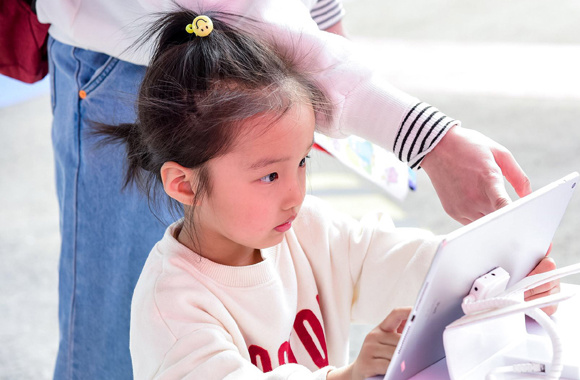 A girl tries the latest livestreaming courses of Xueersi Online School in Beijing. Photo provided to China Daily