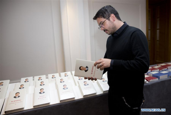 A man reads a book of the second volume of Xi Jinping: The Governance of China before a seminar with the theme of China in the New Era in London, Britain, on April 11, 2018. (Xinhua/Isabel Infantes)