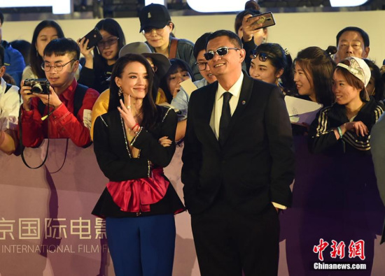 Filmmaker Wong Kar-wai and actress Shu Qi pose on the red carpet before the opening ceremony of the 8th Beijing International Film Festival (BJIFF) in Beijing, April 15, 2018. (Photo: China News Service/Zhai Lu)
