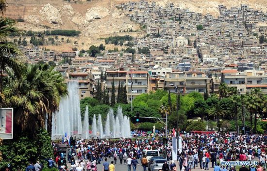 Syrians gather during a pro-government rally held at the Umayyad Square, in Damascus, Syria, on April 16, 2018. Thousands of Syrians in Damascus thronged the Umayyad Square celebrating the military victory in Eastern Ghouta despite the U.S.-led attack on Syrian military positions. (Xinhua/Ammar Safarjalani)