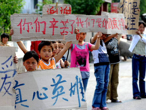 Children in quake-hit Qingchuan county hold banners reading