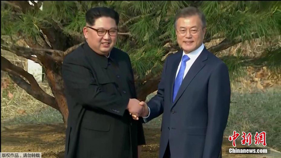 South Korean President Moon Jae-in Rand Kim Jong Un, top leader of the Democratic People's Republic of Korea (DPRK), shake hands after planting a pine tree beside a path near the military demarcation line, April 27, 2018. (Photo/TV screenshot)