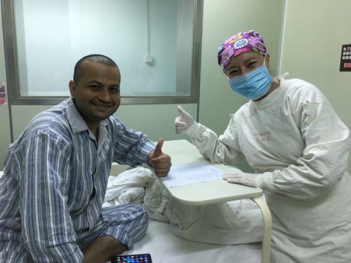 Pakistani patient Tahseen Dilbar poses for a photo with a medical staff member at Shanghai General Hospital on Thursday. (Photo provided to China Daily)