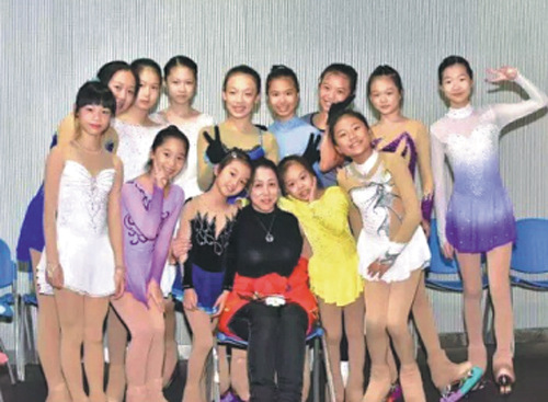 Bao Zhenhua (center) poses with kids she coaches in Fuzhou, Fujian province. (Photo/Xinhua)