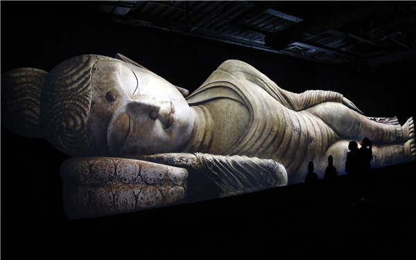 Visitors admire the image of a reclining Buddha that was presented using 3D technology during an exhibition in Shanghai on Wednesday. The exhibition, which features images from the Mogao Grottoes, presents 100 artifacts related to the ancient Silk Road. It opened on Saturday and will run for 10 months. (Photo/China News Service) Visitors admire the image of a reclining Buddha that was presented using 3D technology during an exhibition in Shanghai on Wednesday. The exhibition, which features images from the Mogao Grottoes, presents 100 artifacts related to the ancient Silk Road. It opened on Saturday and will run for 10 months. (Photo/China News Service)